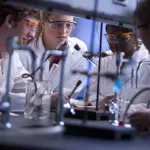 Students perform chemistry experiments in a lab.