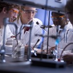 Students perform chemistry experiments in a lab.