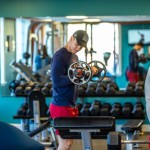 Young man lifting weights in a gym