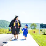 A woman and child both wearing cap and gown