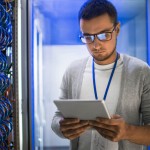 man in computer room looking at iPad