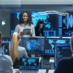 woman surrounded by computers and people