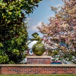 Bronze statue of a boy studying while seated on a globe
