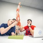 DPT teacher and students examine musculoskeletal model