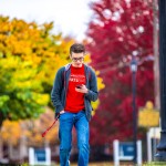 A student looking at their phone while walking