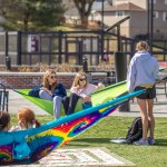 Students sitting on hammocks in a courtyard