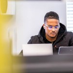 A student using a laptop indoors. 