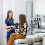 woman checks a patient's blood pressure