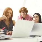 A group of people looking at a laptop