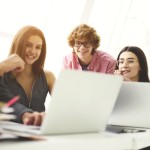 A group of people looking at a laptop