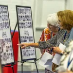 Alumni look at class photos during the 2023 Homecoming celebration