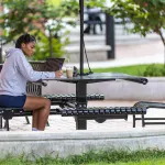 A student sits outside in the quad doing coursework 