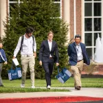 Students speak with a business professor following the annual forum. 