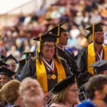 Students stand during commencement and are recognized for their academic accomplishments. 