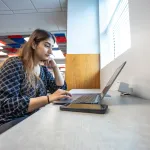 A graduate business student studies in the library. 