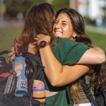 Students hug on their way to class. 
