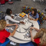 Students play cards around a table in the student center.