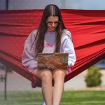 A student works on a computer from her hammock.