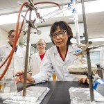 A chemistry professor shows an experiment to students in a lab.