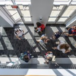 Students walk through the foyer of the library. 