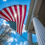 An American flag is displayed on a building on campus. 