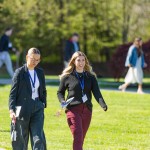 Two female business students walk across campus during the annual business forum. 