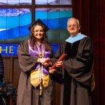 A female honors student accepts her diploma from President Cockrum. 