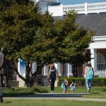 Two students walk on campus near the Lincoln statue. 