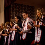 Nursing graduates hold candle and read their oath during a ceremony. 