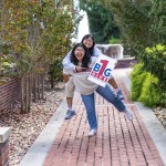 Two female students promote the One Big Give event while standing in front of the fountain. 