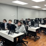 Students work on a computer exercise during a Day of Cyber event. 