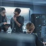 A woman and man look at a computer inside an office studying machine learning. 