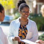A female health worker is getting other women to complete a survey.