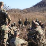 A group of Army ROTC cadets listen to their commander during a field exercise in the fall. 