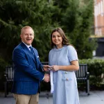 President Young presents a leadership award to student Isabella Watson.