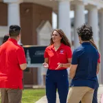 A female physical therapy student leads a discussion among a group of students. 