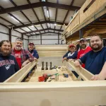 A group of Cumberlands staff members show off a bed they constructed during a service day event.