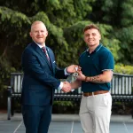 President Young presents an academic award to graduate Jacob Canada.