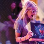 A female holds a Lego set she won during a college orientation event. 