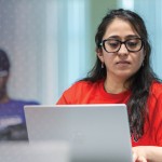 A female students engages in research while on her computer in class. 