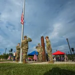 ROTC cadets salute next to the American flag and the 9/11 remembrance memorial on the Cumberlands campus.