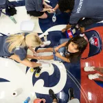 A college volunteer washes the feet of a local student prior to giving her a new pair of shoes during the annual Shoes 4 the Soul event. 