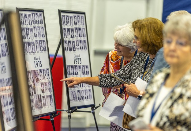 Alumni look at class photos during the 2023 Homecoming celebration