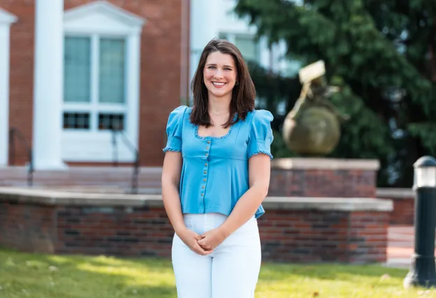 Student Ana Muse poses for a photo in front of the Luecker Building. 